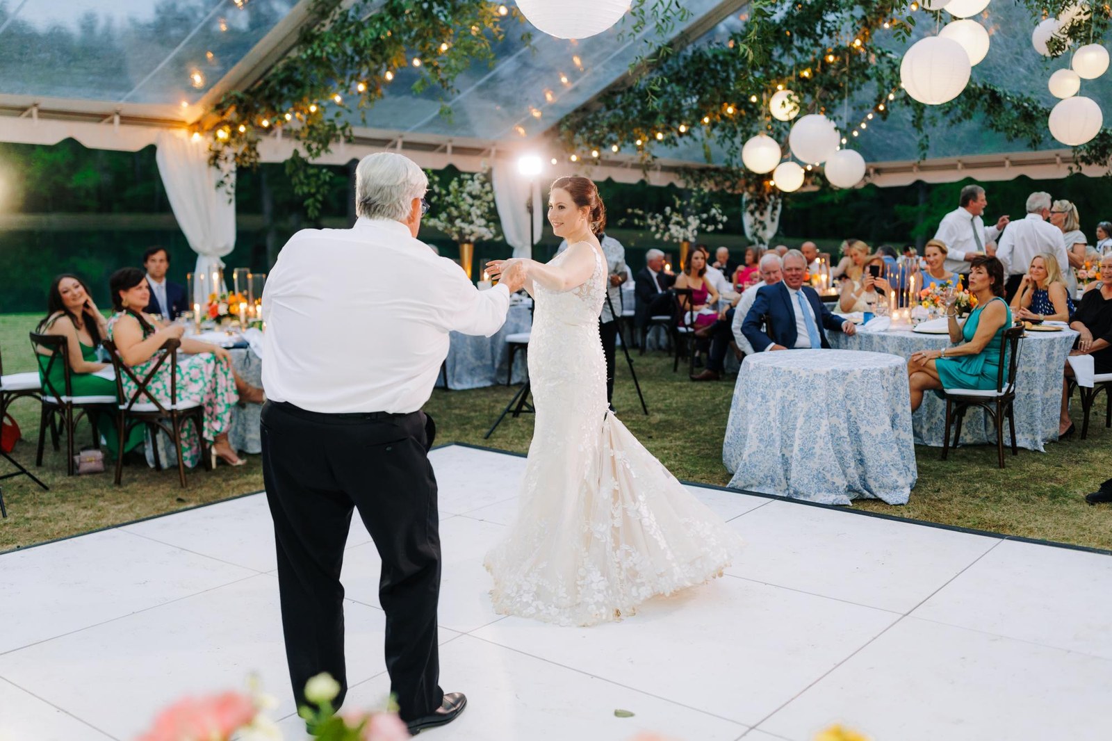 Solid white dance floor set up under string lights and paper lanterns for a father daughter dance in Tulsa
