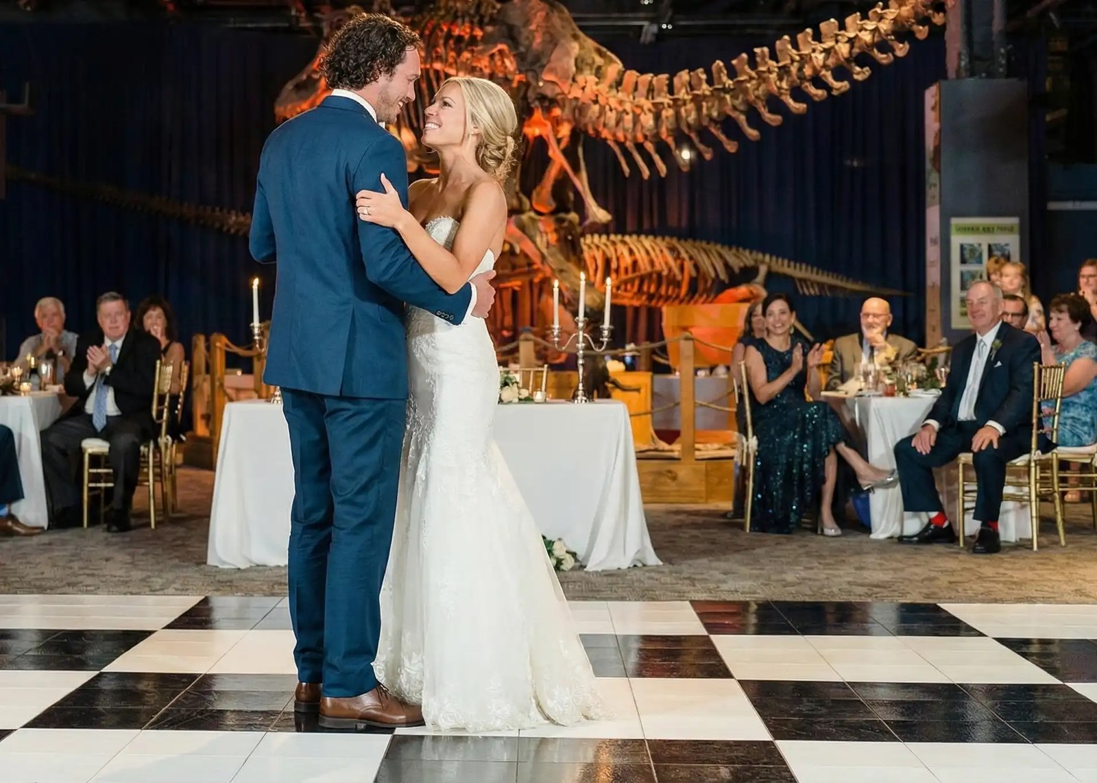 Couple dancing energetically on a dance floor under a tent at a Tulsa wedding reception
